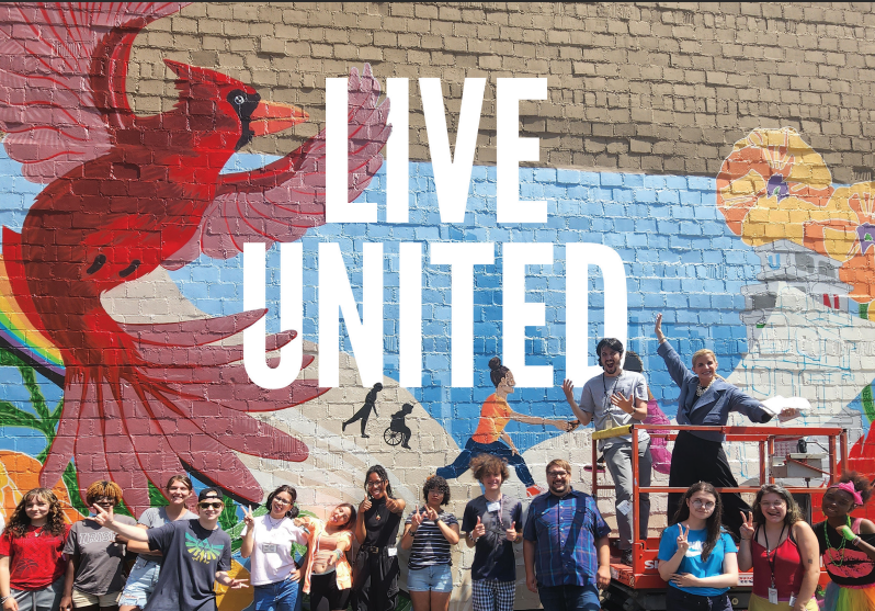 YAAW students and UW staff posing in front of mural